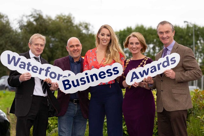 Group standing with signs for Waterford Business Awards