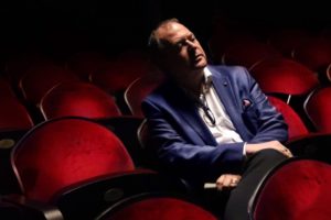 Dieter Kaegi Artistic Director of BVOF sits in a theatre with red chairs